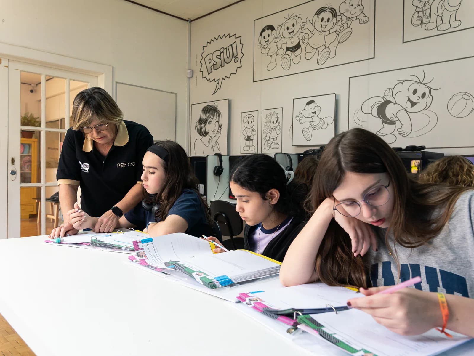 Educadora acompanhando alunas durante uma atividade na Ensina Mais